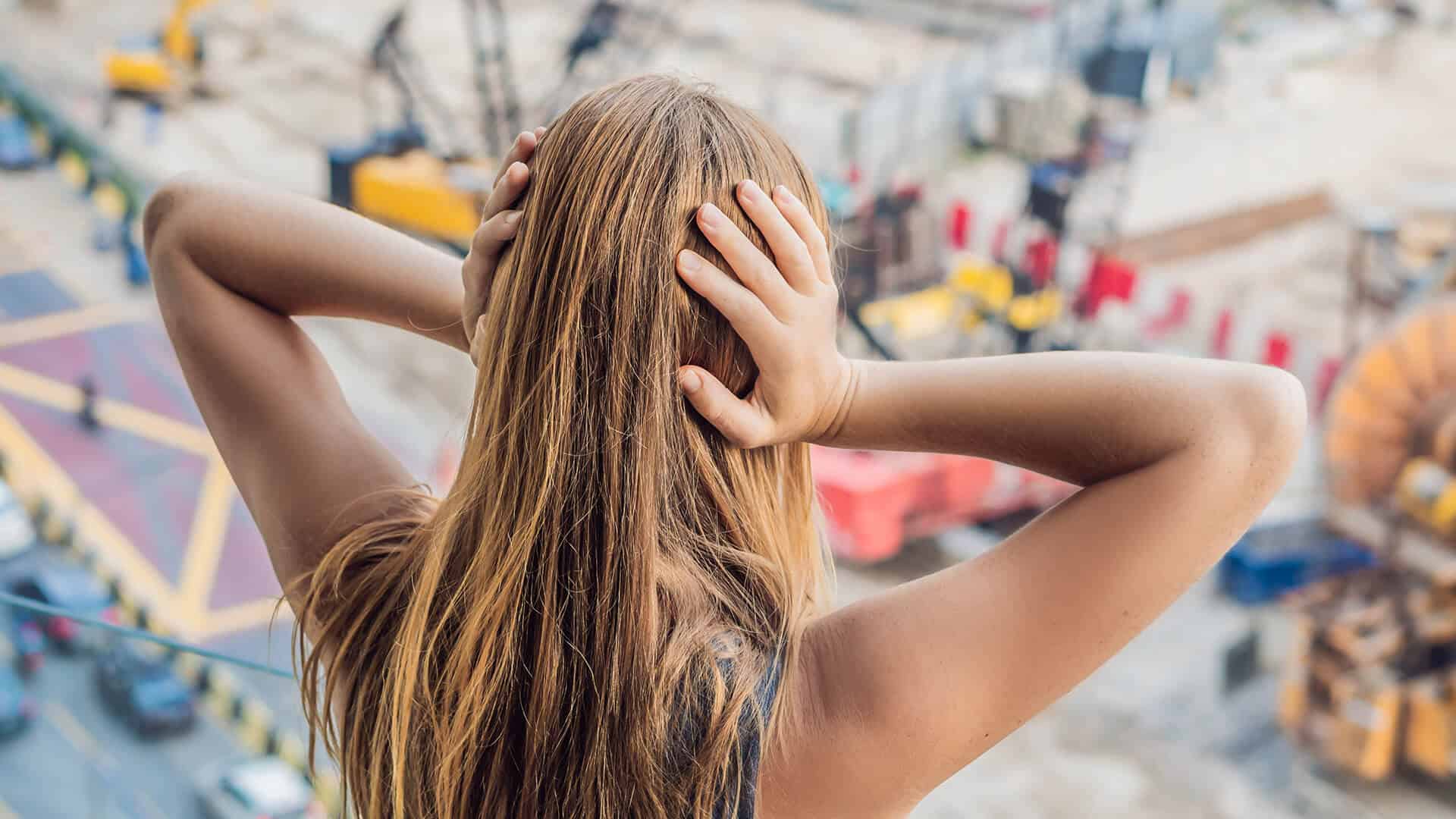 A Woman By The Window Covering Her Ears