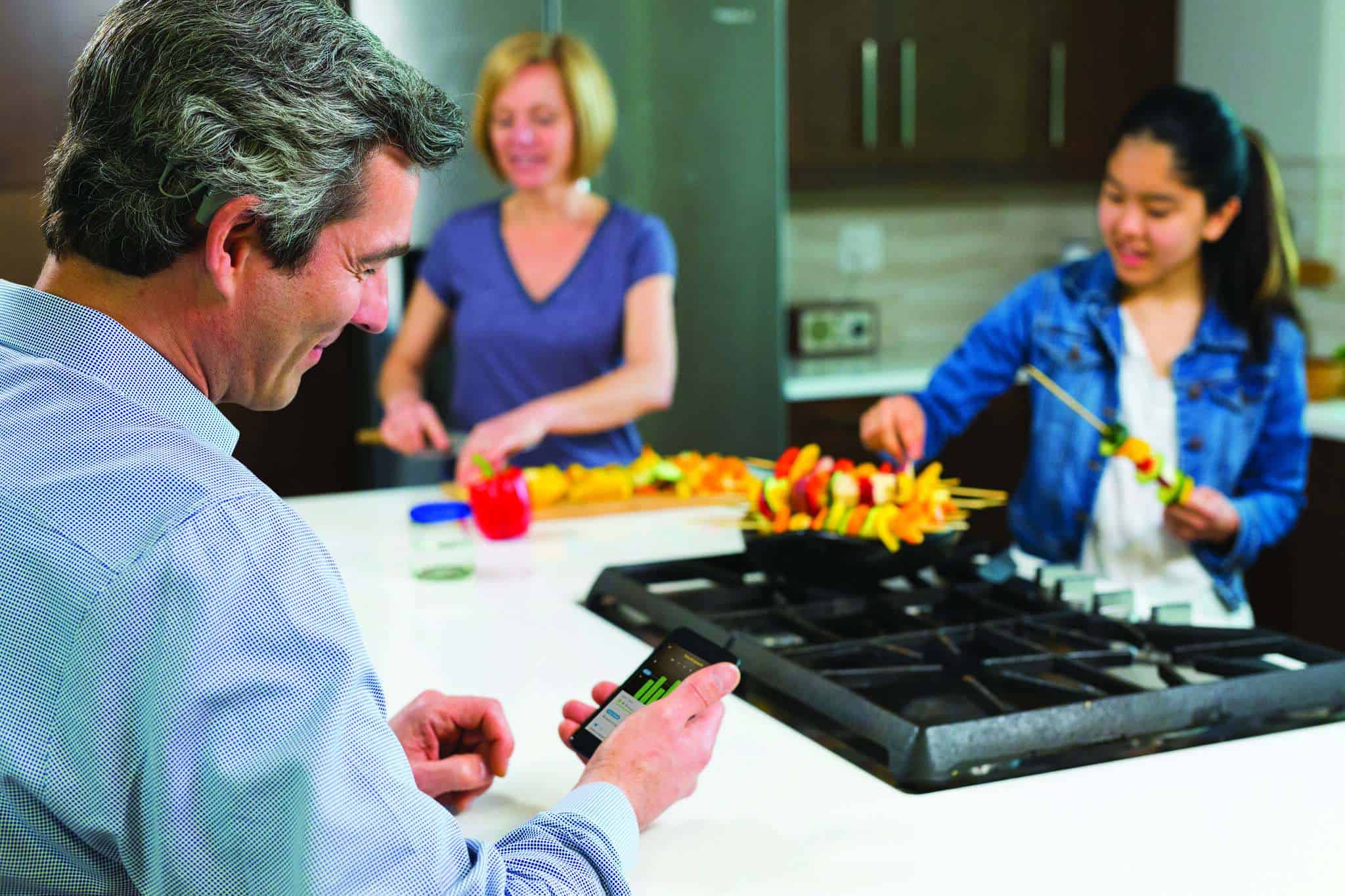 Family preparing meal, whilechecking app