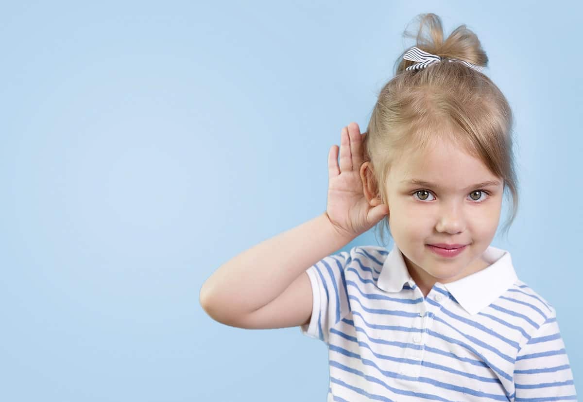 little girl cupping ear because she cant hear