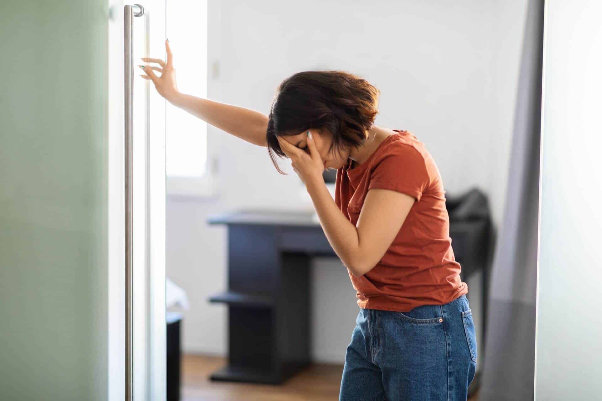 woman holding head in pain